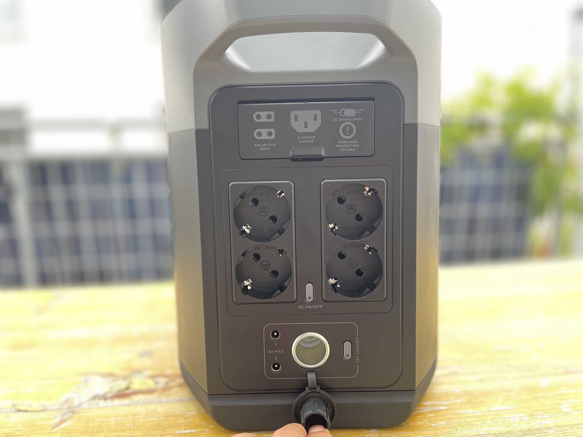 Die Vorderseite des EcoFlow Delta 2 Max Solargenerators mit 4x Schuko,1x Auto (12,6 V / 10 A) und den Solarports hinter einer Klappe.